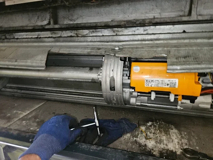 Riparazione tapparelle a Ravenna: motore centrale di una serranda sull'albero, durante la regolazione
