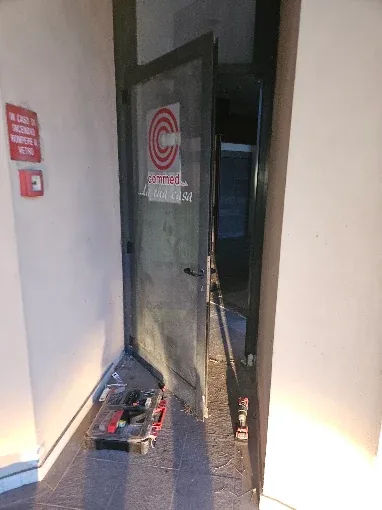 Lavoro di Eugenio a Cotignola: porta di un negozio aperta durante l'intervento